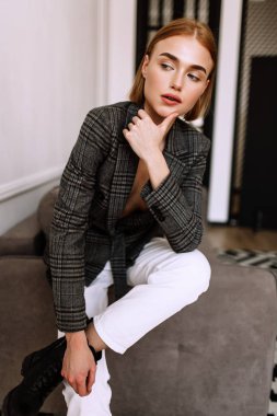 Güzel, tatlı bir kız, çıplak bir vücut ceketi giymiş. Kısa saçlı altın şık model, dolgun dudaklar, rahat giyim, kostüm, kıyafet. Model testi, giyim reklam