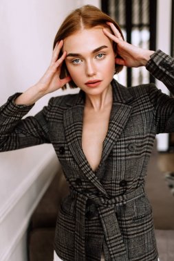 Güzel, tatlı bir kız, çıplak bir vücut ceketi giymiş. Kısa saçlı altın şık model, dolgun dudaklar, rahat giyim, kostüm, kıyafet. Model testi, giyim reklam