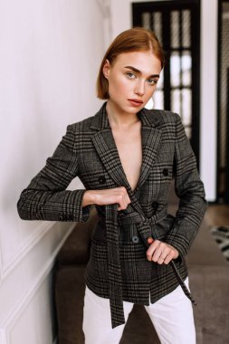 Güzel, tatlı bir kız, çıplak bir vücut ceketi giymiş. Kısa saçlı altın şık model, dolgun dudaklar, rahat giyim, kostüm, kıyafet. Model testi, giyim reklam