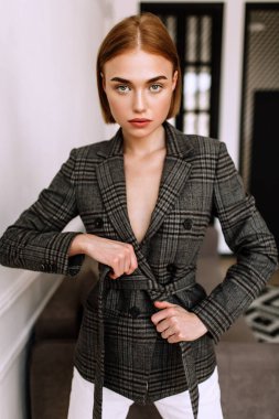 Güzel, tatlı bir kız, çıplak bir vücut ceketi giymiş. Kısa saçlı altın şık model, dolgun dudaklar, rahat giyim, kostüm, kıyafet. Model testi, giyim reklam