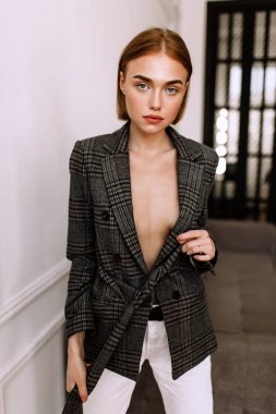 Güzel, tatlı bir kız, çıplak bir vücut ceketi giymiş. Kısa saçlı altın şık model, dolgun dudaklar, rahat giyim, kostüm, kıyafet. Model testi, giyim reklam