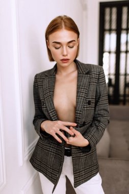 Güzel, tatlı bir kız, çıplak bir vücut ceketi giymiş. Kısa saçlı altın şık model, dolgun dudaklar, rahat giyim, kostüm, kıyafet. Model testi, giyim reklam