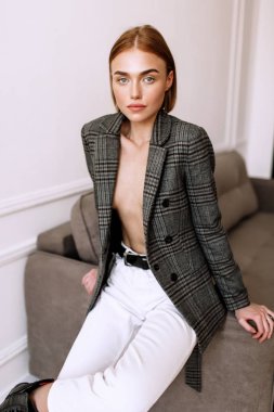 Güzel, tatlı bir kız, çıplak bir vücut ceketi giymiş. Kısa saçlı altın şık model, dolgun dudaklar, rahat giyim, kostüm, kıyafet. Model testi, giyim reklam