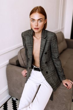 Güzel, tatlı bir kız, çıplak bir vücut ceketi giymiş. Kısa saçlı altın şık model, dolgun dudaklar, rahat giyim, kostüm, kıyafet. Model testi, giyim reklam