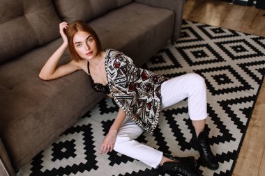 Güzel tatlı kız profesyonel kamera poz. Kısa kırmızı saçlı altın şık model, dolgun dudaklar, rahat giyim, kostüm, kıyafet, sütyen. Model testi, giyim reklam