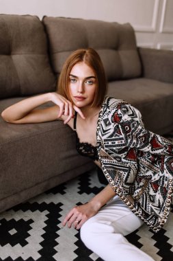 Güzel tatlı kız profesyonel kamera poz. Kısa kırmızı saçlı altın şık model, dolgun dudaklar, rahat giyim, kostüm, kıyafet, sütyen. Model testi, giyim reklam