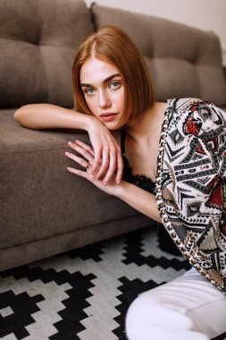 Güzel tatlı kız profesyonel kamera poz. Kısa kırmızı saçlı altın şık model, dolgun dudaklar, rahat giyim, kostüm, kıyafet, sütyen. Model testi, giyim reklam