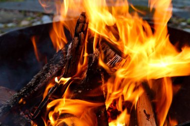 Kamp ateşinde yüksek alevlerle yanan odun.