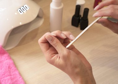 Manikür ve manikür, evde güzellik, kız tek başına manikür yapıyor.