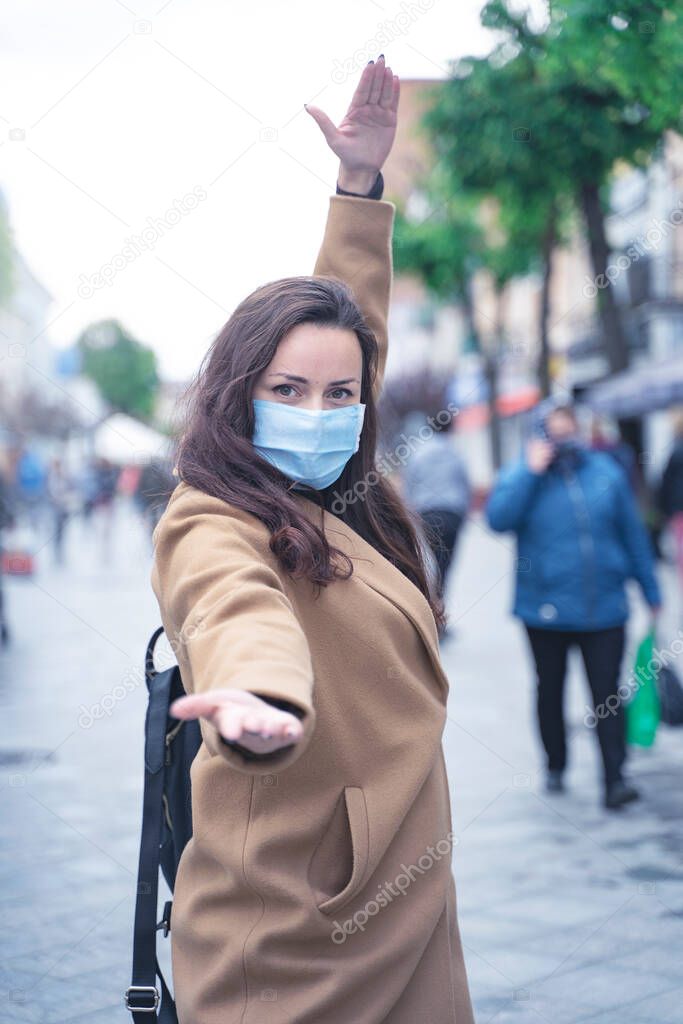 girl in a medicine mask walking on the street, protection from the virus, social distance in a public place