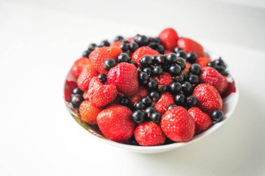 Frenk üzümü ve çilek tabakta, taze meyveler.