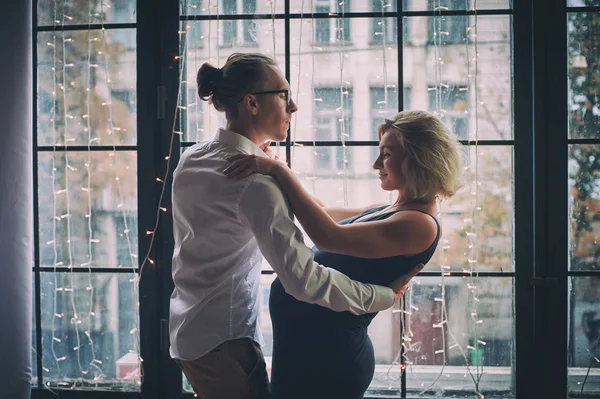 Man and pregnant woman dance near window in loft style room — Stock Photo, Image