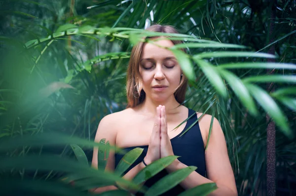 Portrét roztomilá mladá žena meditaci a dělá namaste ruku v džungli. Slunečný den — Stock fotografie