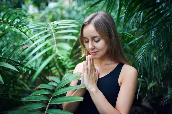 Portrét roztomilá mladá žena meditaci a dělá namaste ruku v džungli. Slunečný den — Stock fotografie