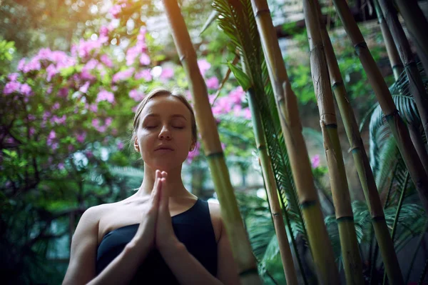 Portrét roztomilá mladá žena meditaci a dělá namaste ruku v džungli. Slunečný den — Stock fotografie