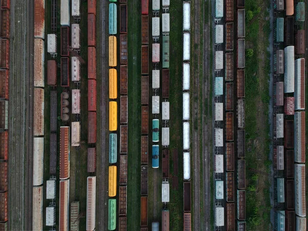 Aerial view of a cargo trains. Colorful freight trains on the railway station. Heavy industry. Top view from flying drone