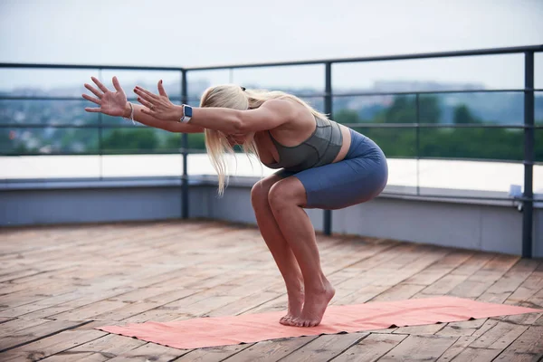 금발에 몸매의 여자는 테라스 위에서 위에서 운동을 — 스톡 사진