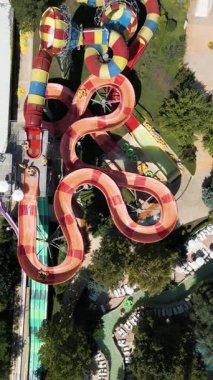 Su parkında şişme borulara binen insanların renkli su kaydıraklarının havadan görünüşü. Parlak yaz günü heyecan, eğlence ve heyecanla dolu..