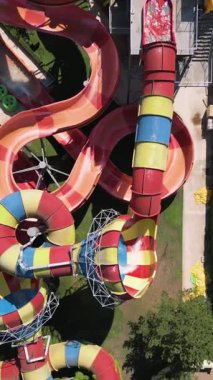 Su parkında şişme borulara binen insanların renkli su kaydıraklarının havadan görünüşü. Parlak yaz günü heyecan, eğlence ve heyecanla dolu..