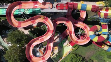 Su parkında şişme borulara binen insanların renkli su kaydıraklarının havadan görünüşü. Parlak yaz günü heyecan, eğlence ve heyecanla dolu..