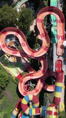 Su parkında şişme borulara binen insanların renkli su kaydıraklarının havadan görünüşü. Parlak yaz günü heyecan, eğlence ve heyecanla dolu..