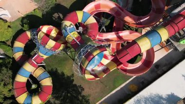 Su parkında şişme borulara binen insanların renkli su kaydıraklarının havadan görünüşü. Parlak yaz günü heyecan, eğlence ve heyecanla dolu..