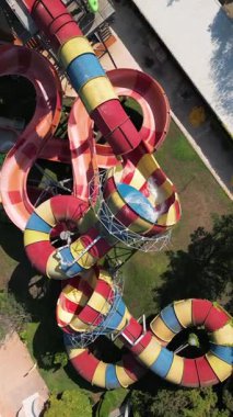 Su parkında şişme borulara binen insanların renkli su kaydıraklarının havadan görünüşü. Parlak yaz günü heyecan, eğlence ve heyecanla dolu..