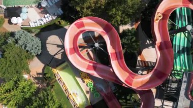 Su parkında şişme borulara binen insanların renkli su kaydıraklarının havadan görünüşü. Parlak yaz günü heyecan, eğlence ve heyecanla dolu..