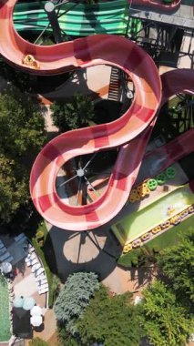 Su parkında şişme borulara binen insanların renkli su kaydıraklarının havadan görünüşü. Parlak yaz günü heyecan, eğlence ve heyecanla dolu..