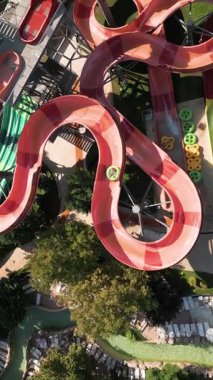 Su parkında şişme borulara binen insanların renkli su kaydıraklarının havadan görünüşü. Parlak yaz günü heyecan, eğlence ve heyecanla dolu..