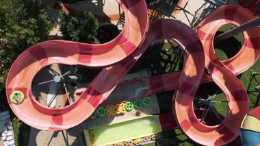 Su parkında şişme borulara binen insanların renkli su kaydıraklarının havadan görünüşü. Parlak yaz günü heyecan, eğlence ve heyecanla dolu..