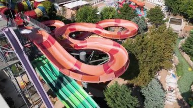 Su parkında şişme borulara binen insanların renkli su kaydıraklarının havadan görünüşü. Parlak yaz günü heyecan, eğlence ve heyecanla dolu..