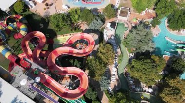 Su parkında şişme borulara binen insanların renkli su kaydıraklarının havadan görünüşü. Parlak yaz günü heyecan, eğlence ve heyecanla dolu..