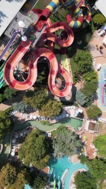 Su parkında şişme borulara binen insanların renkli su kaydıraklarının havadan görünüşü. Parlak yaz günü heyecan, eğlence ve heyecanla dolu..