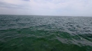 Slow motion video of raindrops falling on the surface of the sea. Calm atmosphere, gentle ripples, and soft lighting create a peaceful, meditative marine scene.