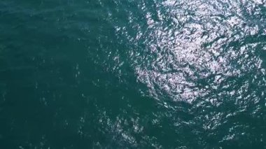 Aerial view of dark ocean surface with shimmering waves under daylight. Abstract natural background for marine, travel, or environmental projects.