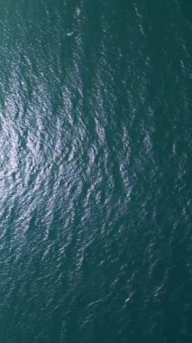 Aerial view of dark ocean surface with shimmering waves under daylight. Abstract natural background for marine, travel, or environmental projects.