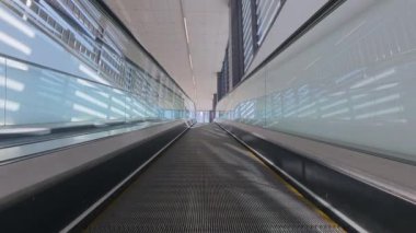 Empty moving walkway in modern airport or shopping mall, travelator perspective view, transport conveyor for passengers.