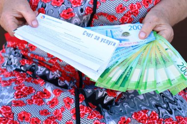 Yaşlı bir kadını elinde hafif ve yeni Rus banknotlar için okundu bilgisi