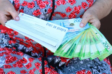 Bir yaşlı kadın kapat-u elinde hafif ve yeni Rus banknotlar için okundu bilgisi
