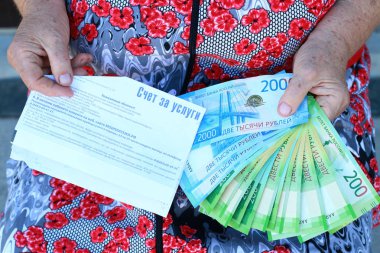 Ödeme ve yaşlı bir kadını elinde Rus parası için okundu bilgisi