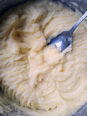 Güveçte patates püresi ile kaşığın fotoğrafı.