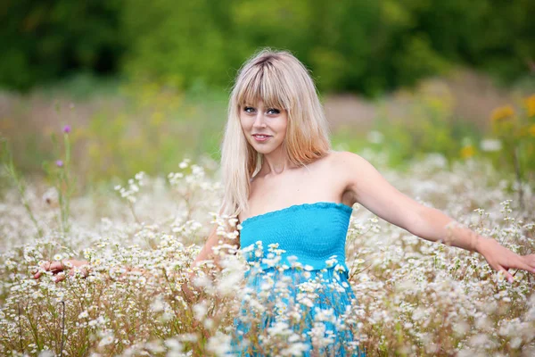 Hermosa chica en un vestido de color turquesa entre las hierbas florecientes —  Fotos de Stock