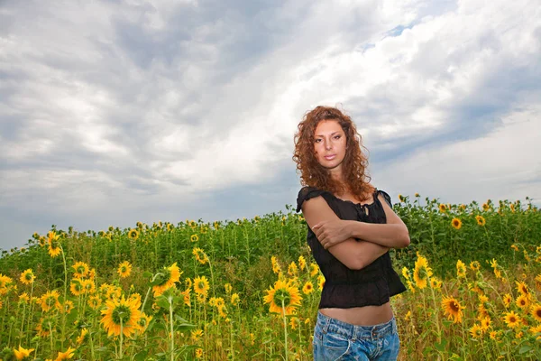 Menina jovem em um contexto de campo de girassóis — Fotografia de Stock