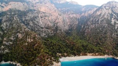 Dalgalar deniz ve plaj sıçramasına havadan görünümü.