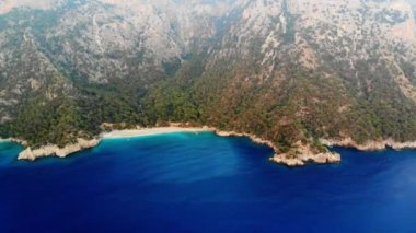 Dalgalar deniz ve plaj sıçramasına havadan görünümü.