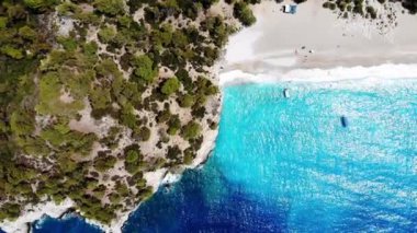 Dalgalar deniz ve plaj sıçramasına havadan görünümü.