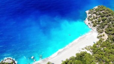 Dalgalar deniz ve plaj sıçramasına havadan görünümü.