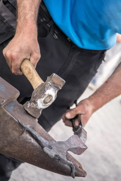 Blacksmiths make artistic smithing of hot metal on an anvil. Blacksmith hammer. Blacksmith tools