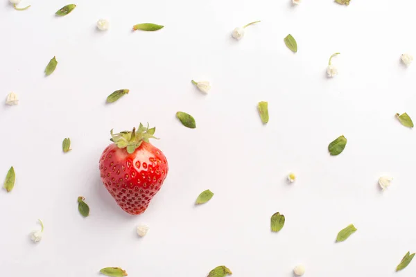 Strawberry creative pattern. Ripe red berry with green leaves on white background